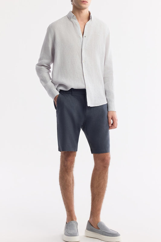 Model wearing anthracite 100% linen shorts with white shirt and grey loafers