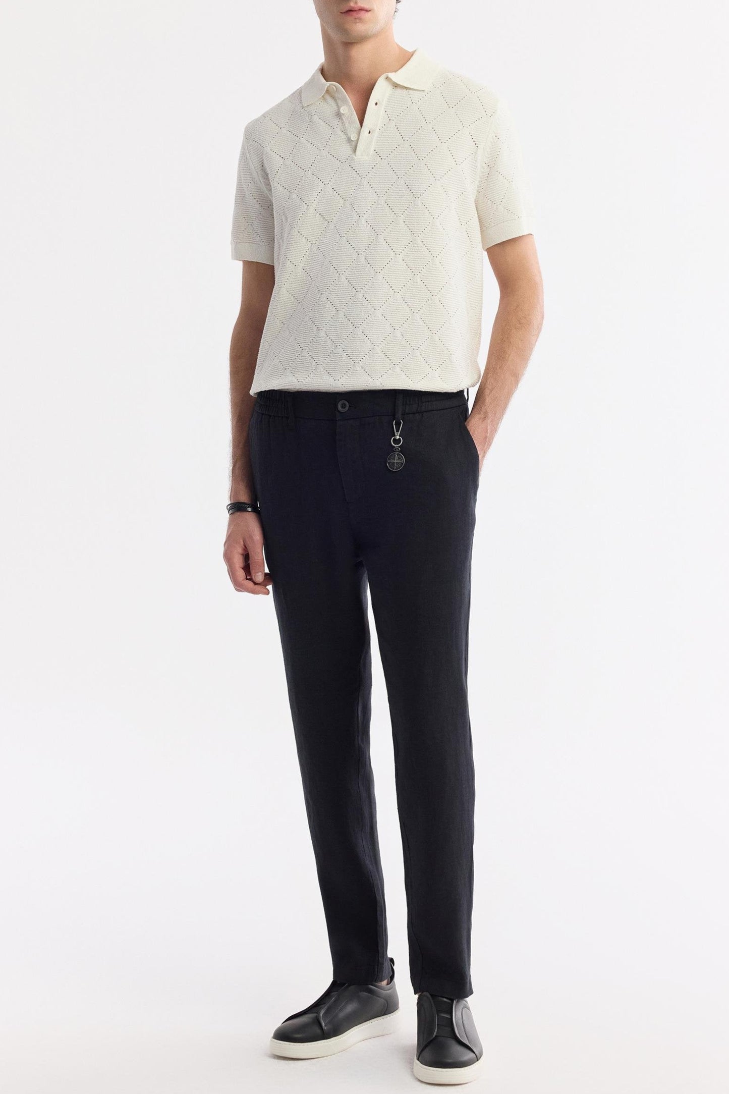 Model pairing black pants with black linen shirt, minimal styling