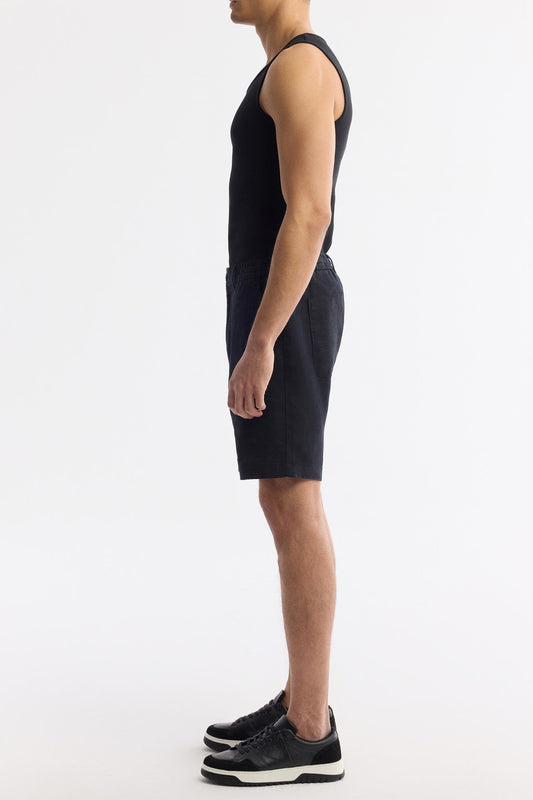 Side view of black linen shorts showing elastic waistband