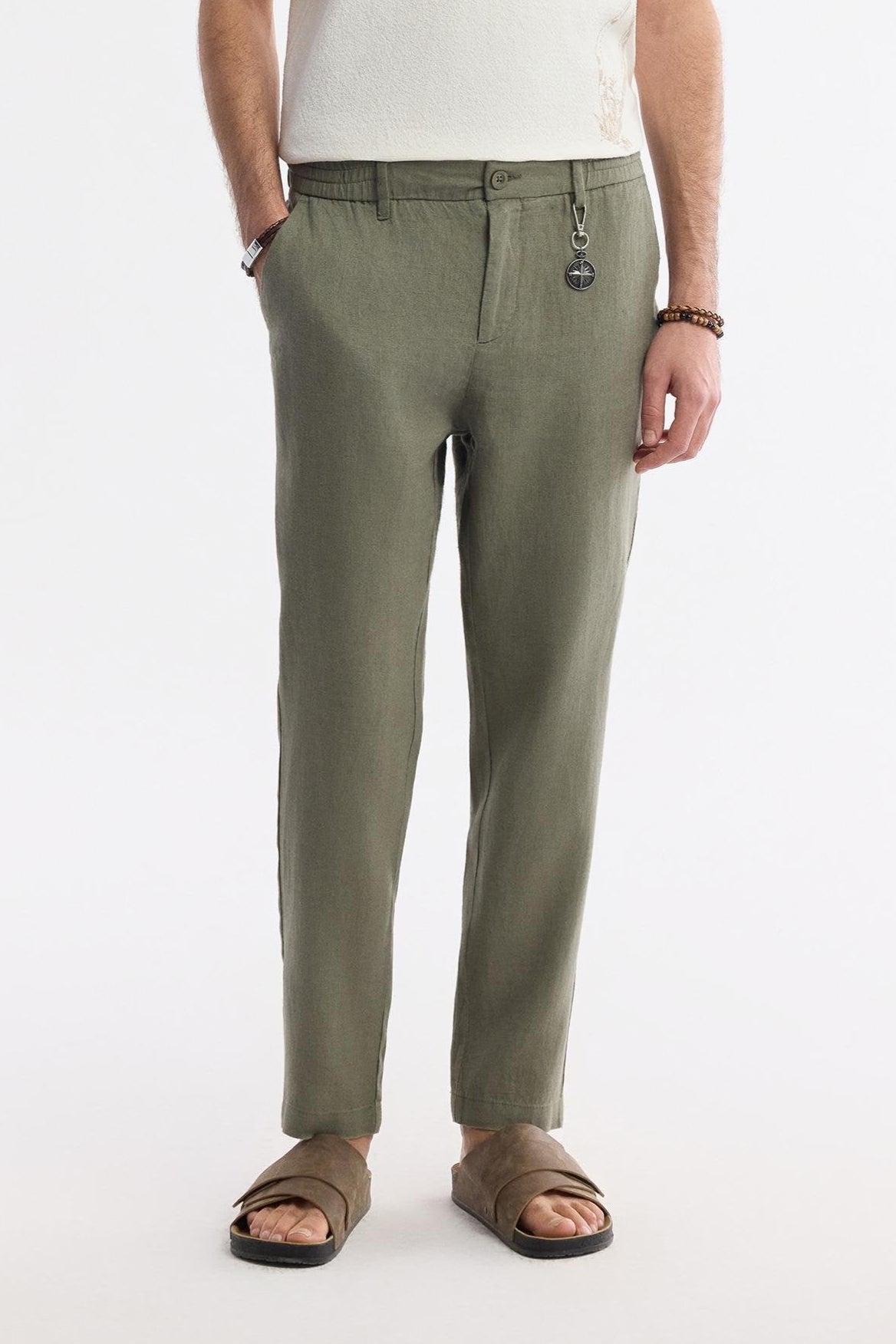 Model wearing Olive Green Linen Pants with white shirt and sandals