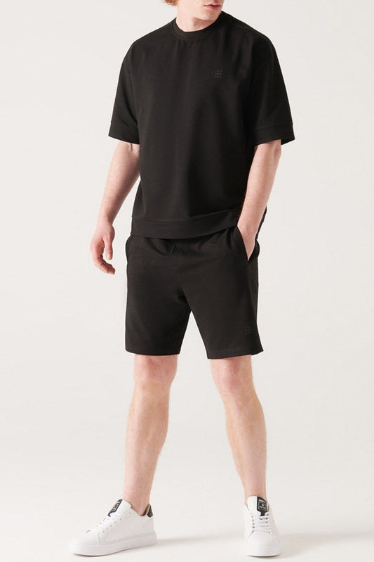 Full-body look: Black shorts paired with black tee and white sneakers