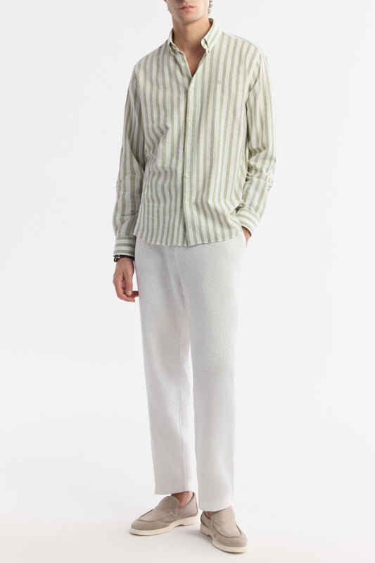 Full body image of model styling green striped shirt with white pants