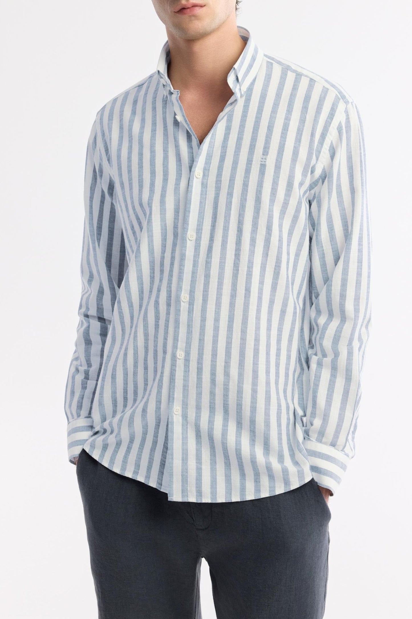 Angled front pose of sky blue striped cotton shirt with hands in pockets – Swiftyle