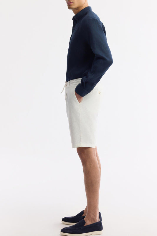 White linen shorts on model, side profile with hands in pockets