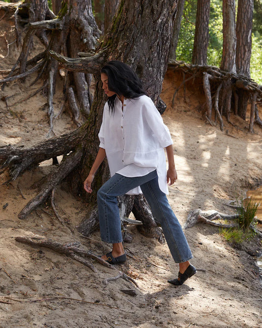 Person walking through a natural setting with large trees and roots.