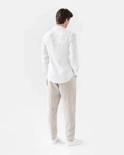 Man wearing a white shirt and beige pants on a white background