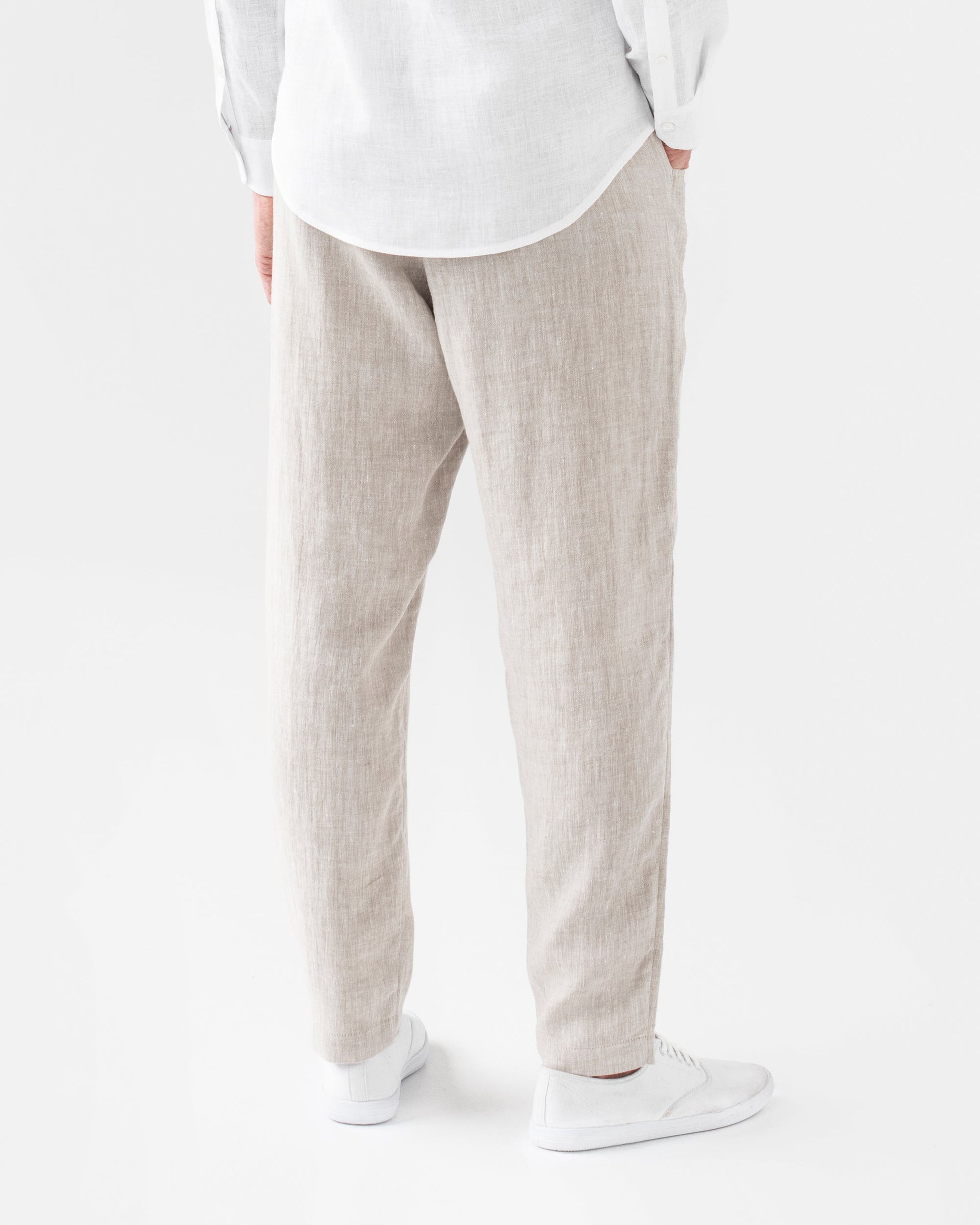Person wearing light-colored pants and a white shirt on a white background
