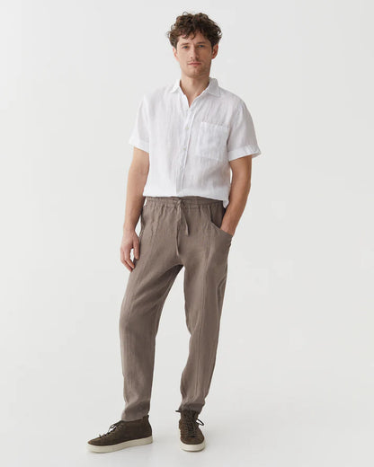 Man wearing a white shirt and brown pants on a white background