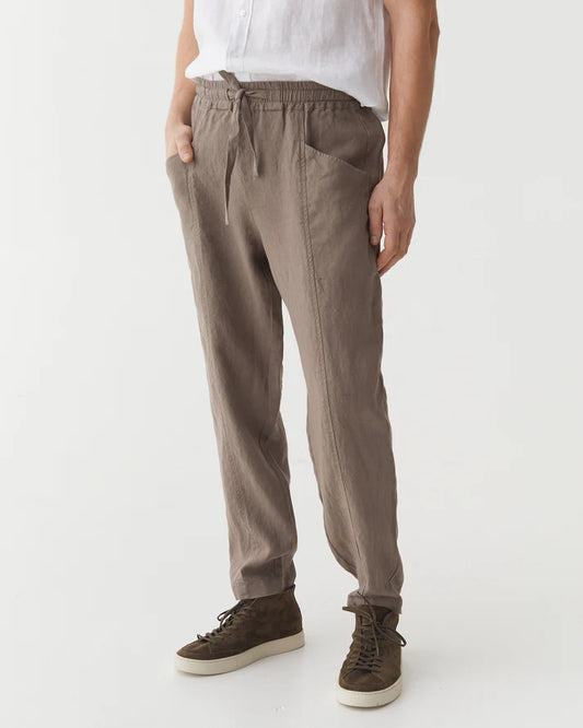 Person wearing brown pants and brown shoes on a white background