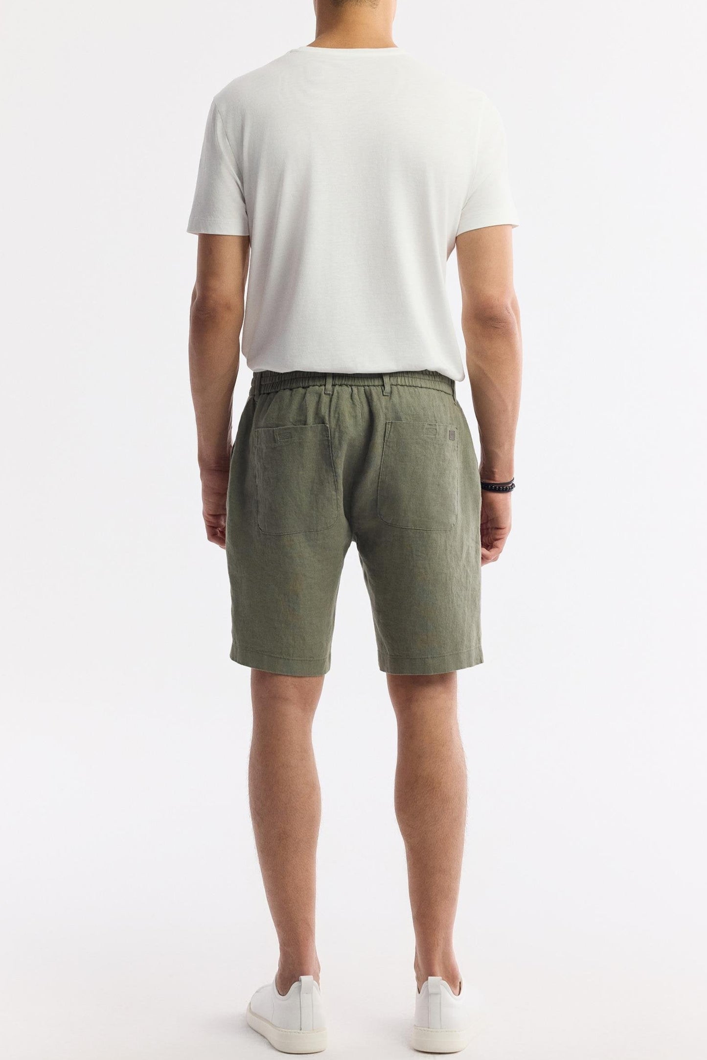 Rear view of olive green linen shorts on model