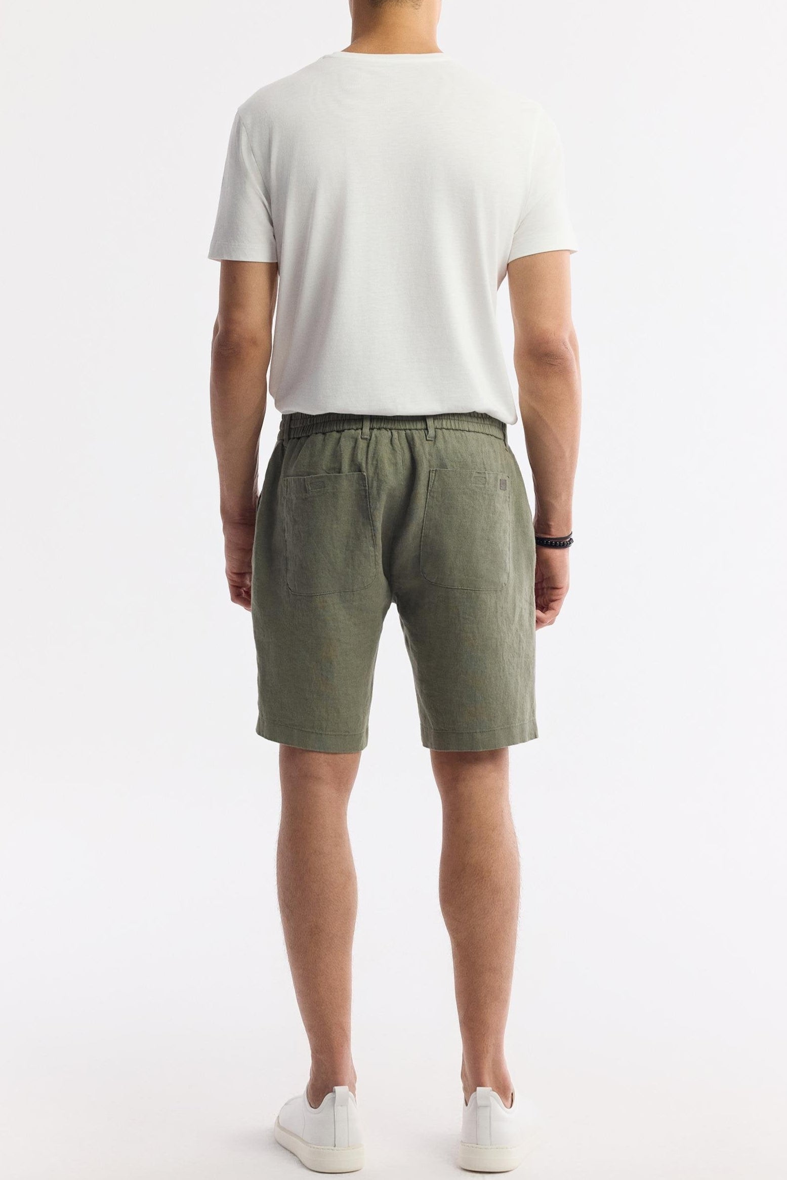 Rear view of olive green linen shorts on model