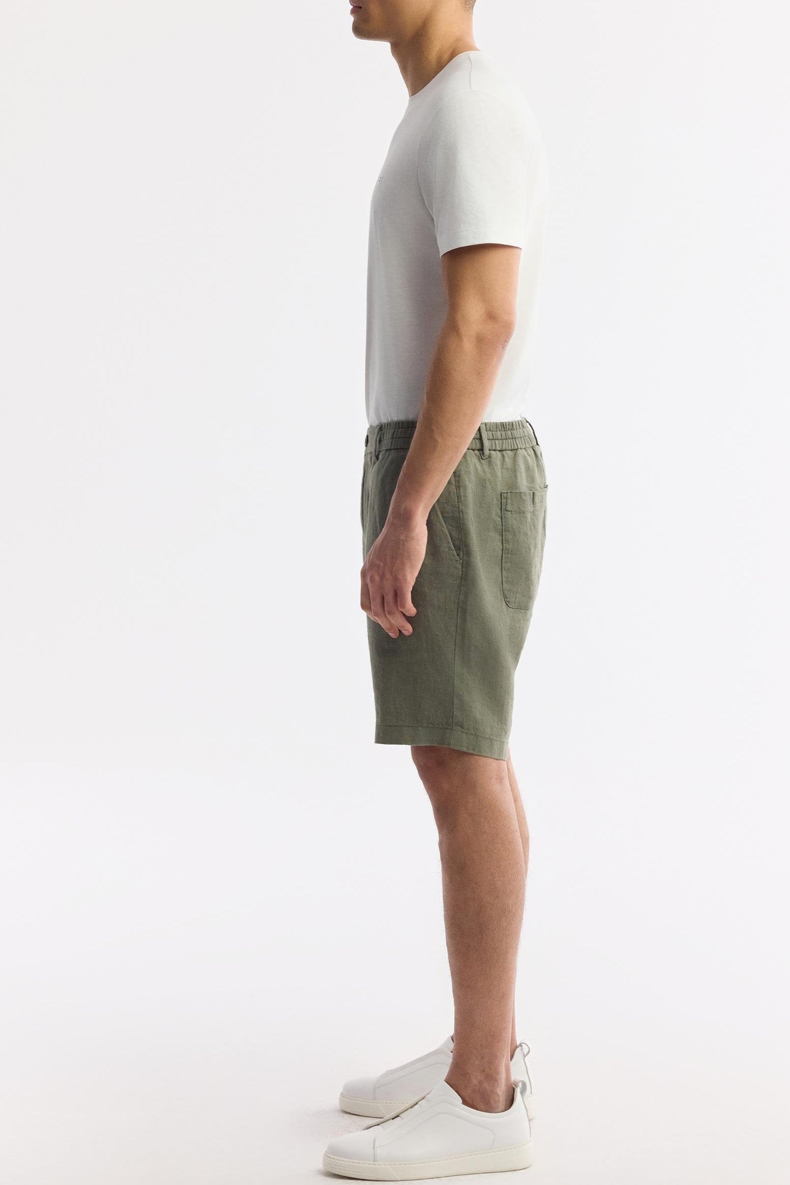 Man wearing olive green linen shorts front view