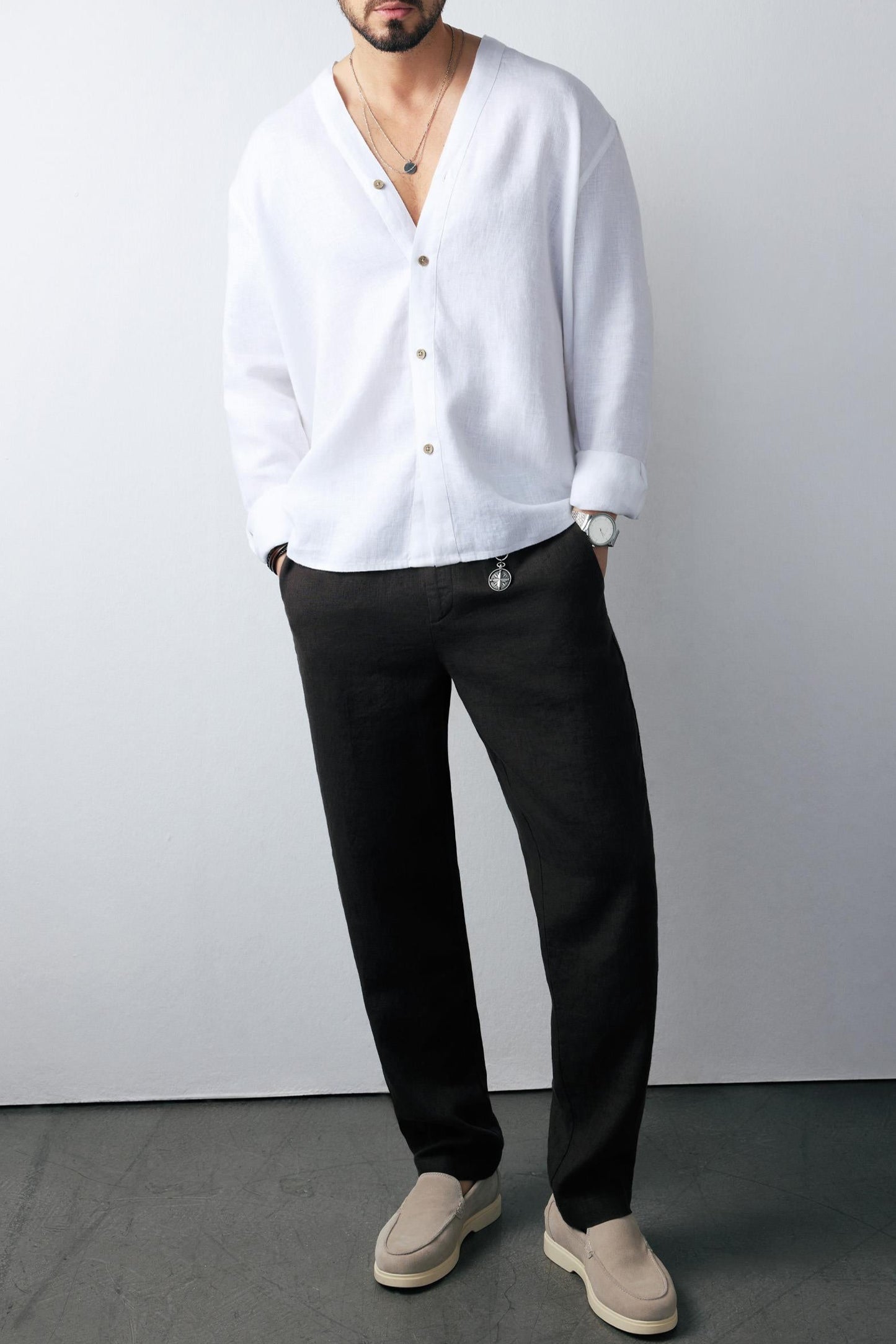 Model pairing black pants with black linen shirt, minimal styling