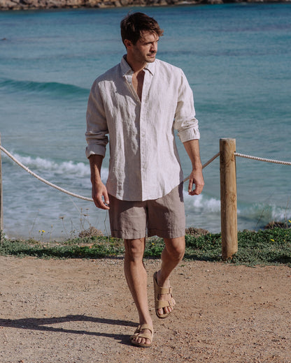 Man walking by a beach with ocean waves in the background