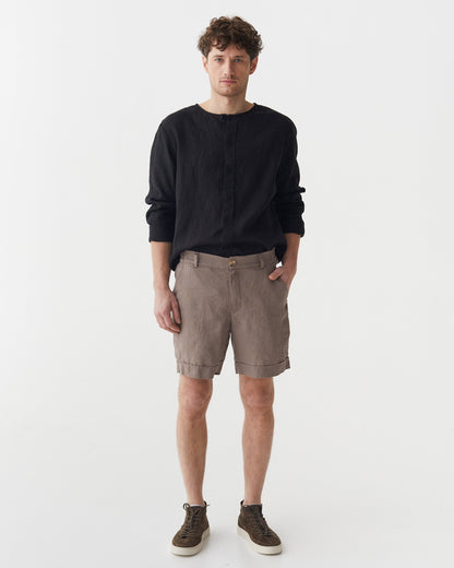 Man wearing a black sweater and brown shorts on a white background