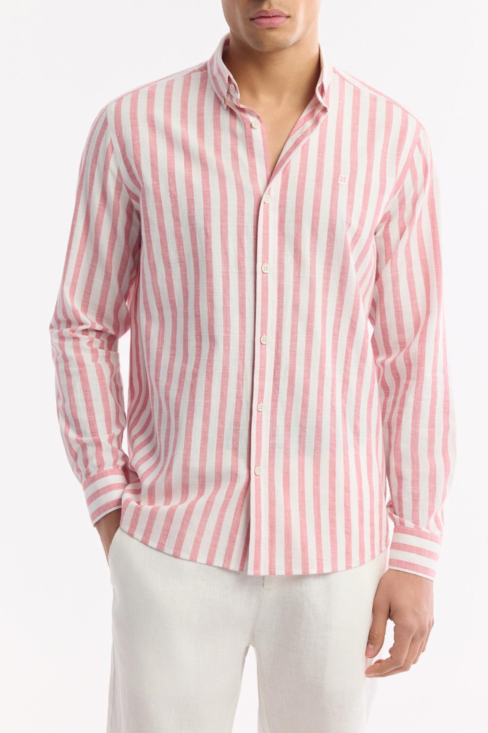 Natural stance in pink striped shirt and white linen