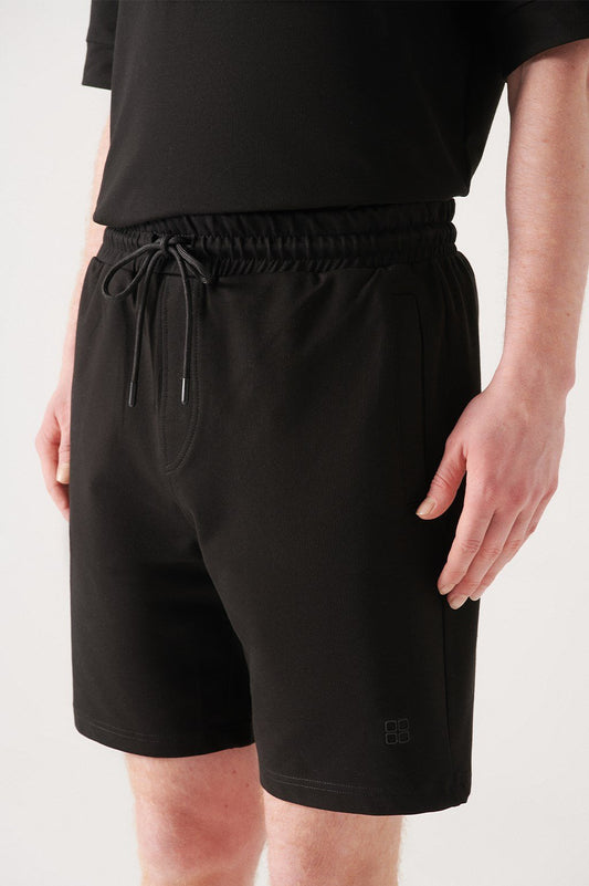 Close-up of drawstring and elastic waistband on black cotton shorts