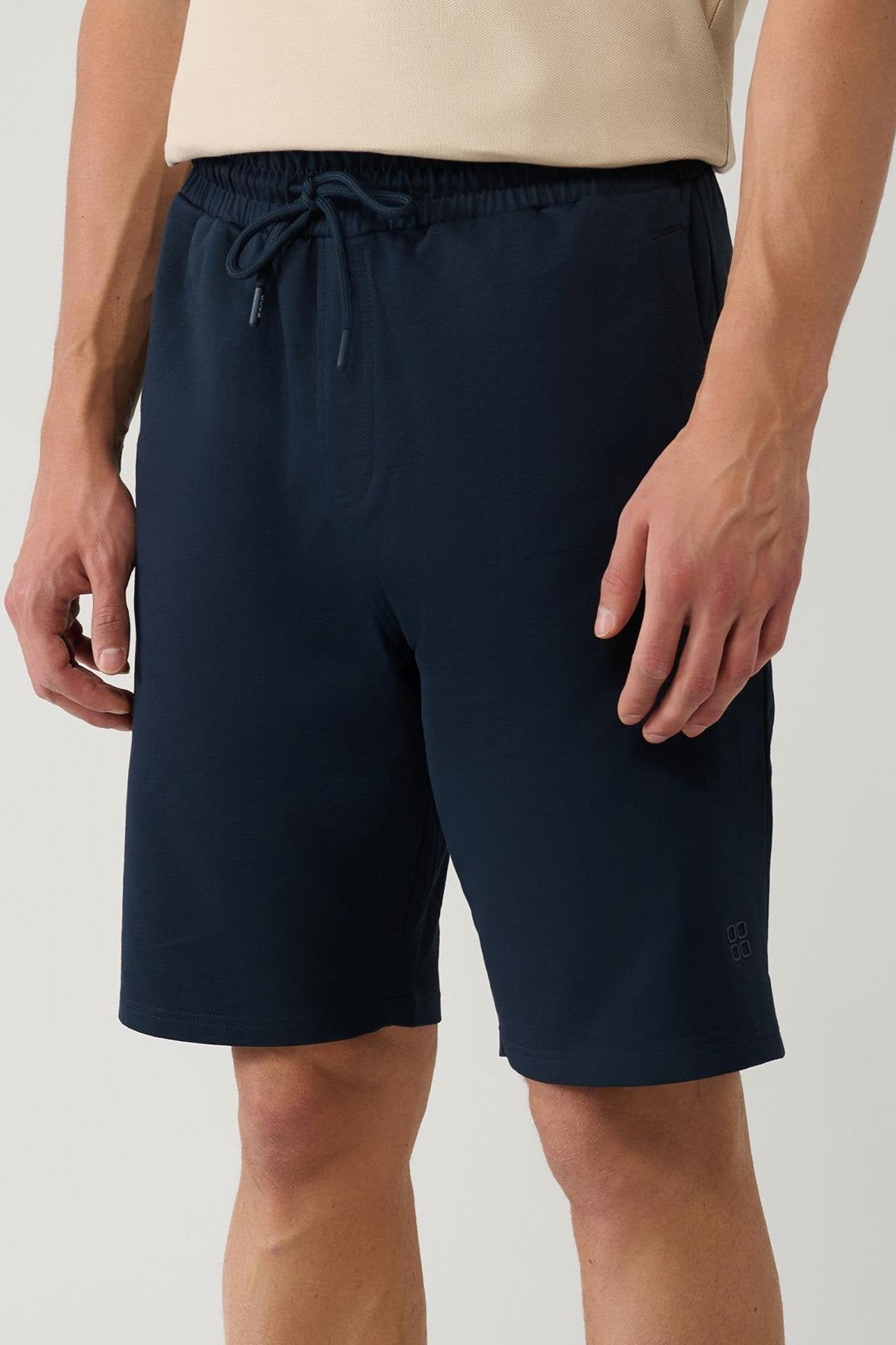 Navy cotton shorts worn with beige polo – side angle – Swiftyle