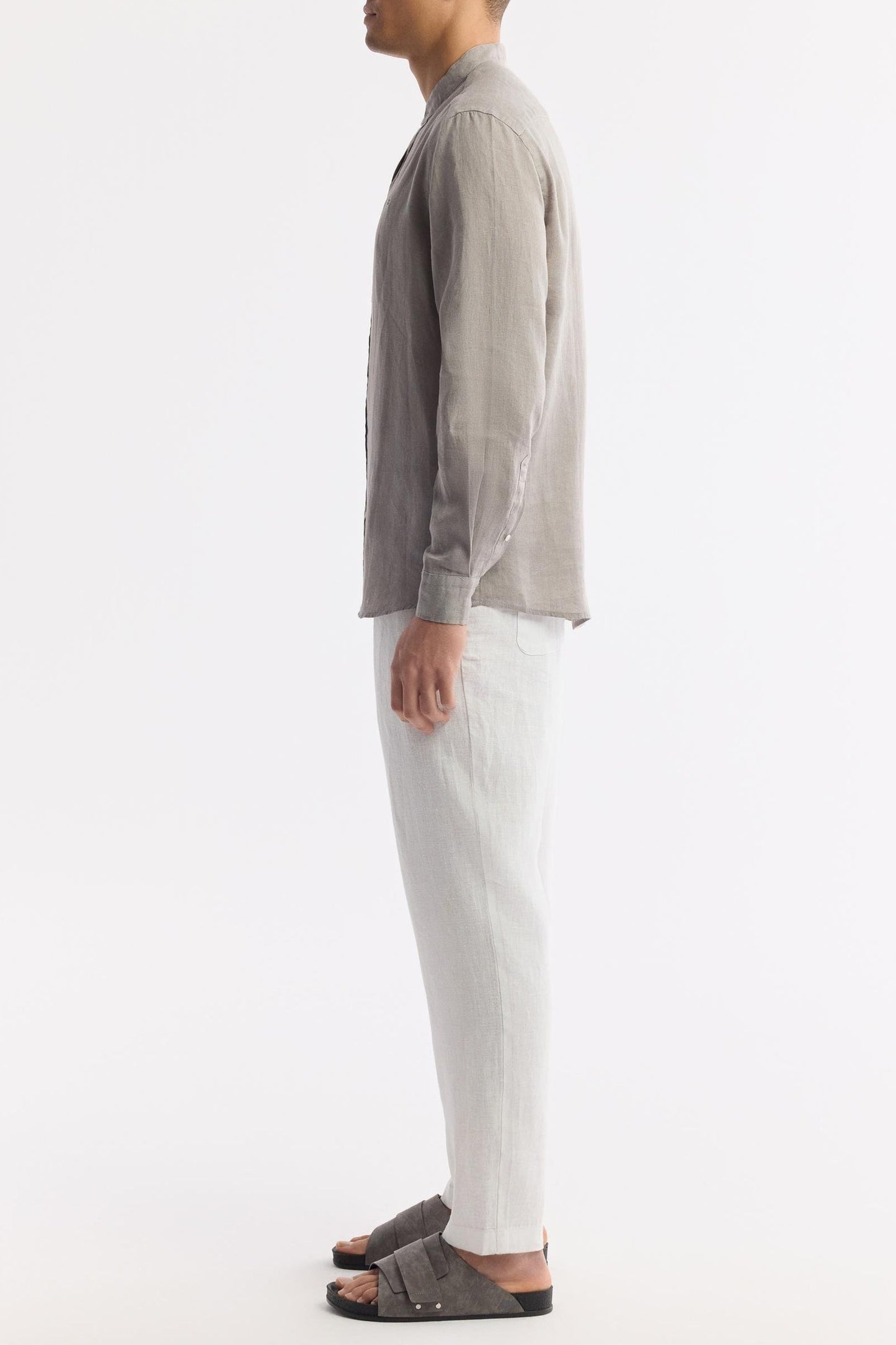Side profile of men’s gray linen shirt with collarless neckline
