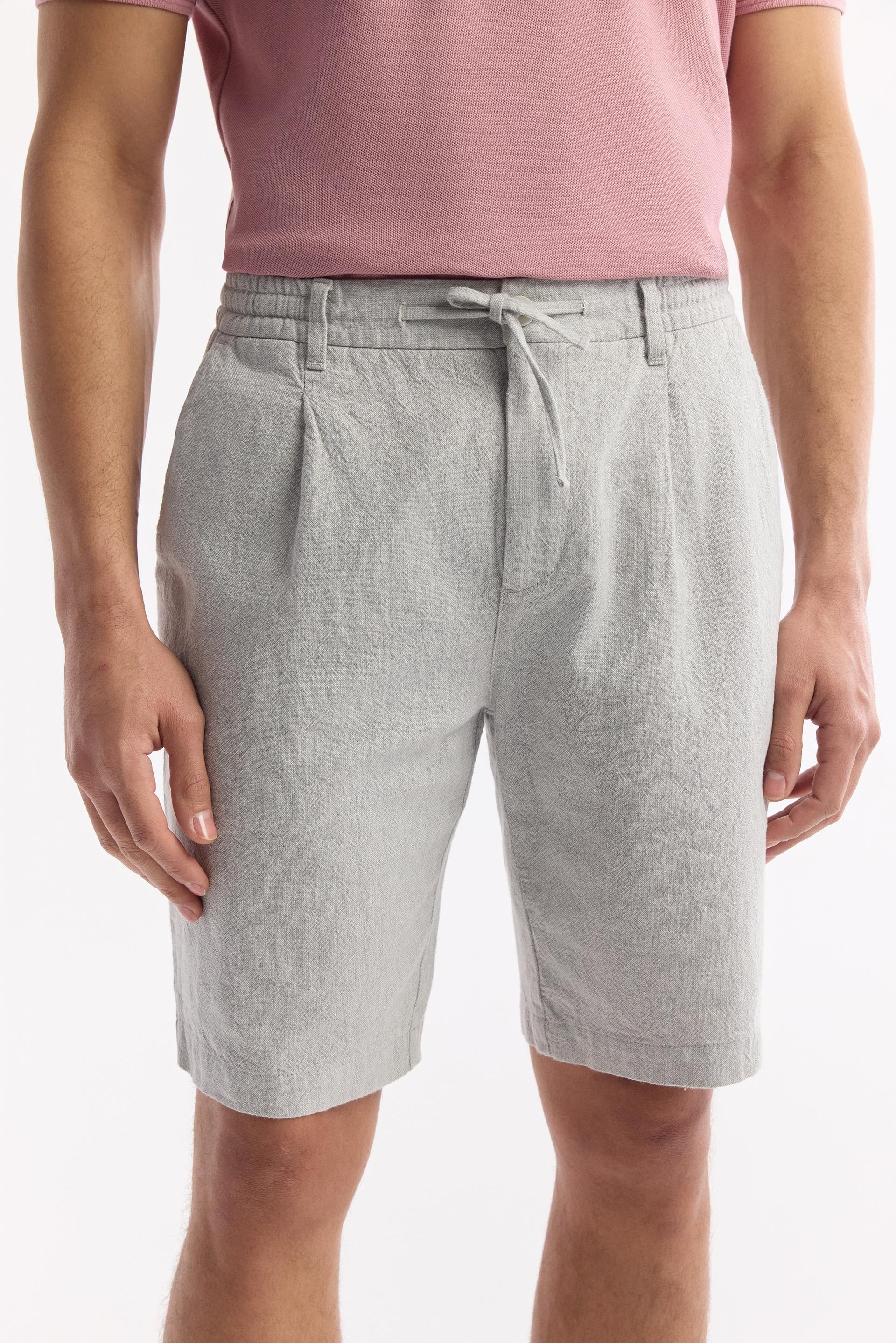 Close-up of drawstring waist and pleats on gray linen shorts – Swiftyle